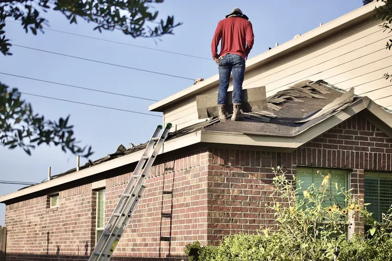 Professional roofer working on a residential roof in Simsbury